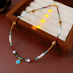 Detailed shot of turquoise pendant and pearl beaded necklace in a luxury jewelry box