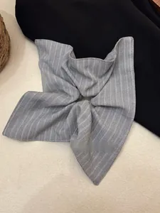 Detail of grey striped fabric hair scrunchie with vertical woven cotton texture
