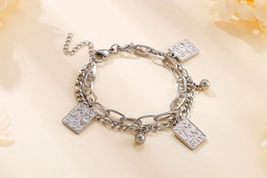 Detail of double-layered stainless steel chain bracelet with rectangular poker card charms