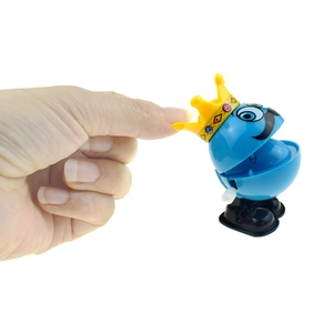 Wind-up jumping clown toy with blue body yellow crown and wind-up key on white background