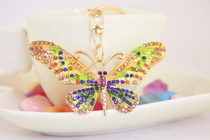 Close-up of golden butterfly keychain with colorful rhinestones and intricate metal wing texture