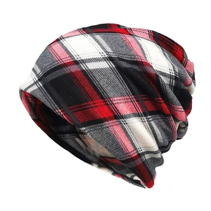 Close-up of red and black plaid knit beanie showing checkered pattern and soft texture