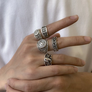 Close-up of five-piece retro silver rings featuring lion, cross, and octopus patterns