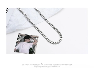 Detail shot of heavy silver titanium steel Cuban link chain with a matte paper background