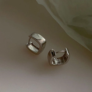 Macro view of minimalist silver geometric square hoop earrings with polished finish