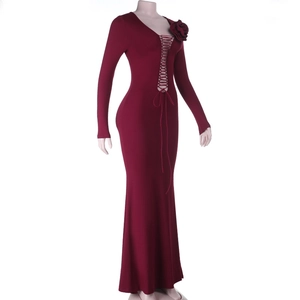 Détail de la robe bordeaux à manches longues avec laçage découpé et rose 3D sur l'épaule