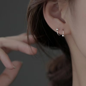 Detail view of 925 sterling silver screw back stud earring on model's ear