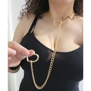 Close-up of golden gothic Cuban chain necklace with heart pendants on a model