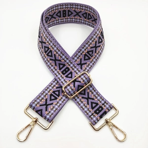 Detail of purple bohemian woven strap with geometric patterns and gold metal hardware