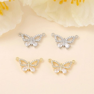 Macro shot of butterfly pendant connectors with cubic zirconia in gold and silver