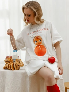 Λεπτομέρεια λευκού βαμβακερού T-shirt με τύπωμα μπάμπουσκα και πέρλες