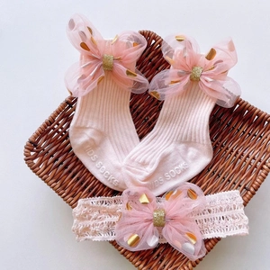 Detail of pink baby socks and lace headband set with sparkling foil heart bows