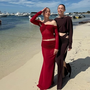 Detail of red and brown long sleeve two-piece skirt sets in a resort beach setting
