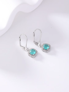 Detail showing silver lever-back earrings with light blue round zircon and halo stones