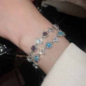 Macro shot of silver flower bracelets featuring light blue and deep purple zircon stones