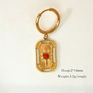 Detail of gold hoop earring with red gemstone pendant and size dimensions