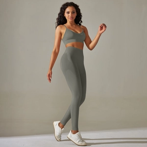 Detail of high-waisted ribbed yoga leggings and thin strap sports bra in dark gray color