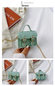 Detail view of mini green jelly crossbody bag with gold chain and magnetic buckle closure
