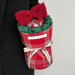 Christmas gift box with red plaid fabric, large red bow and fresh apple inside