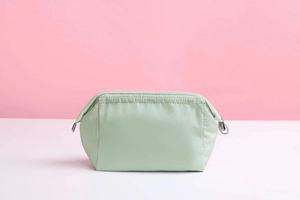 Detailed close-up of light green waterproof cosmetic pouch with smooth nylon fabric