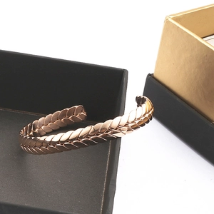 Detail shot of rose gold wheat ear textured open cuff bracelet on jewelry box