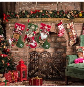 Three Christmas stockings with 3D reindeer, snowman, and Santa hanging on a brick fireplace