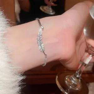 Silver feather bracelet with sparkling zircons worn in an elegant social dinner setting