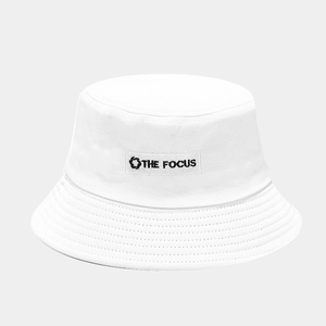 Detail of white canvas bucket hat featuring THE FOCUS embroidery and circular logo