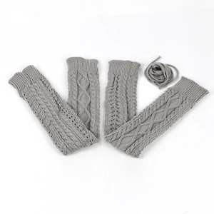 Close-up of gray cable knit leg warmers with ribbon ties and ribbed cuff texture