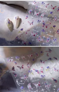 Macro detail of butterfly and flower nail stickers with pink gradient and pearls