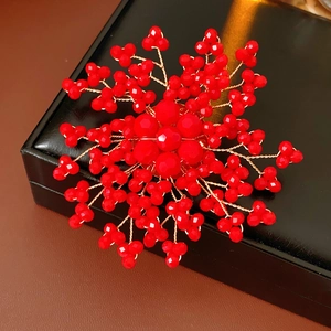 Detail of handmade red pearl flower brooch with gold wire on a leather jewelry box