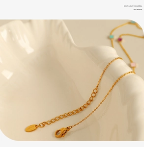 Detail of adjustable 18K gold plated stainless steel chain with lobster clasp on ceramic
