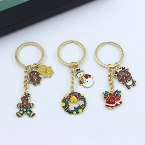 Three gold Christmas keychains featuring gingerbread man, snowman and reindeer charms