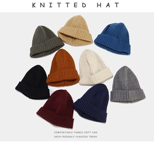 Flat lay of colorful knitted beanies showcasing various colors and ribbed texture