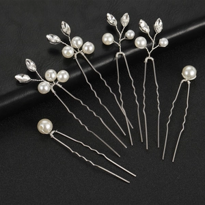 Detail of silver U-shaped hair pins with white pearls and leaf-shaped clear rhinestones