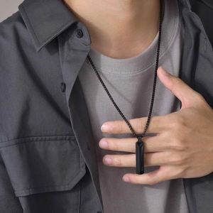 Close-up of a men's minimalist black stainless steel rectangular pendant necklace on a model