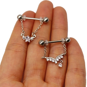 Macro detail of stainless steel nipple rings with star and V-shaped crystal pendants