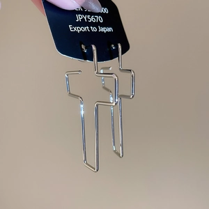 Vue détaillée de boucles d'oreilles croix en argent S925 avec design en métal creux