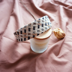 Detail of woven straw headband with geometric patterns on a scented candle aesthetic setting