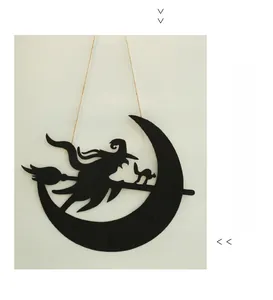 Detail of black Halloween Boo sign with witch and cat silhouette hanging on white wall