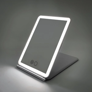 Detail of a portable LED makeup mirror with touch-control dimmer and a folding stand