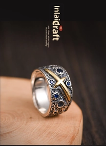 Macro detail of retro 925 silver meteorite ring with bronze cross and blue gems
