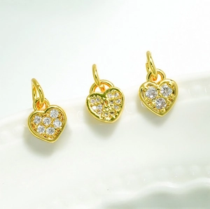 Macro shot of three 18K gold plated heart charms with pavé cubic zirconia for DIY jewelry