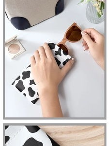 Close-up of cow print leather sunglasses pouch showing the snap opening and soft texture