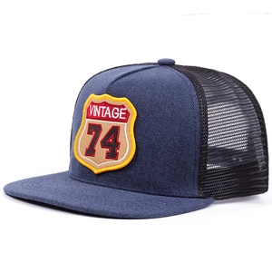 Close-up of vintage 74 embroidery on navy denim and black mesh trucker hat