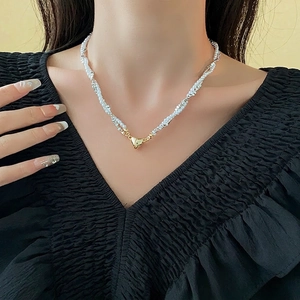 Double-layer pearl and silver bead necklace featuring a golden heart magnetic pendant