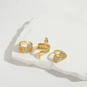 14K gold plated serpent ring set with zircon stones on a white marble stone surface