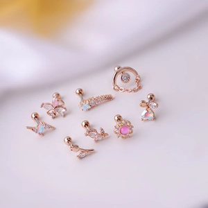 Detail of rose gold stud earrings featuring butterfly, star, and moon shapes with crystals