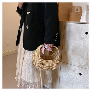 Close-up of a stylish woven rattan basket handbag with a curved handle for women