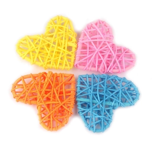Set of four 6cm woven rattan hearts in yellow, pink, orange, and blue on white background